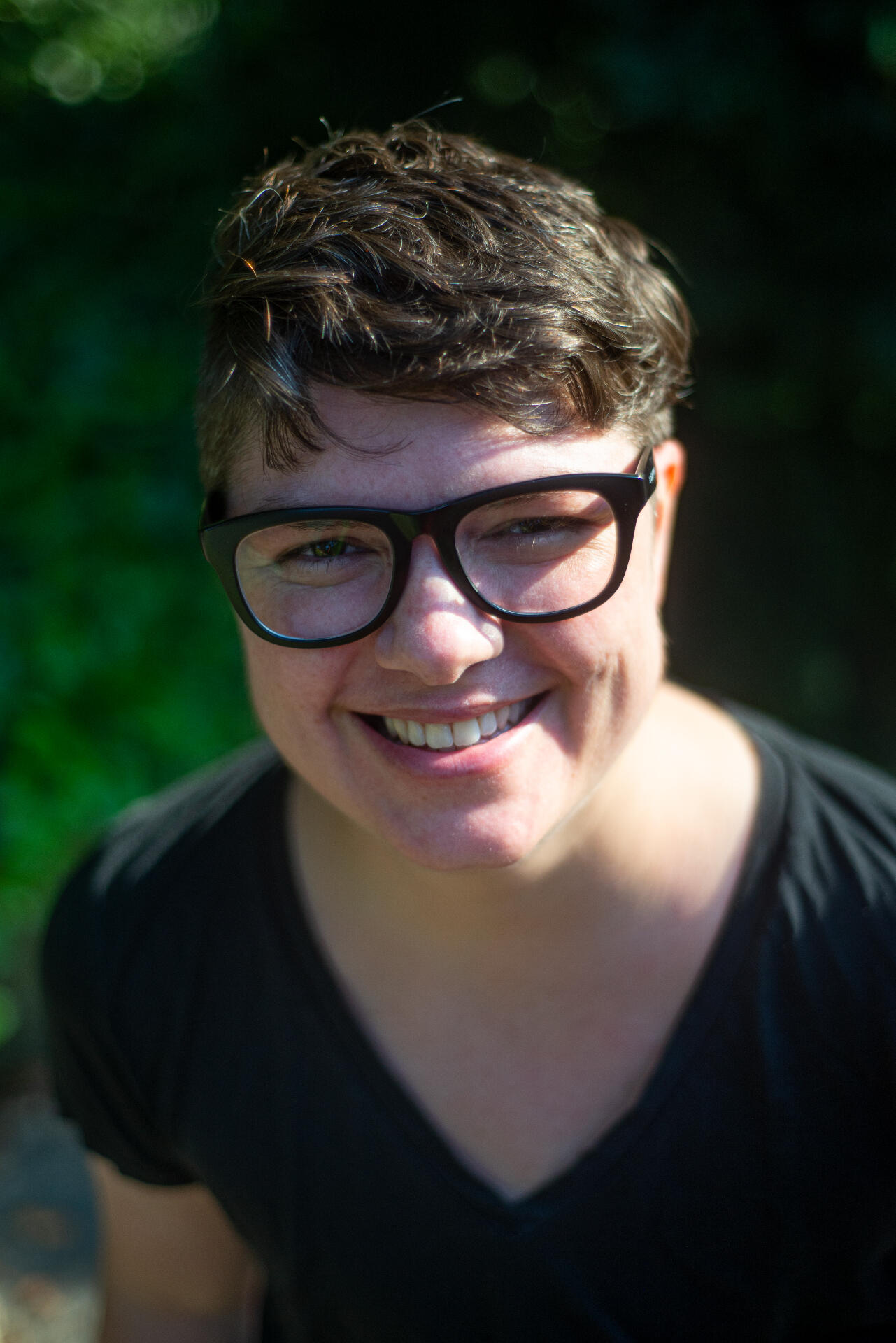 TJ author photo: a white person with black glasses wearing a black shirt